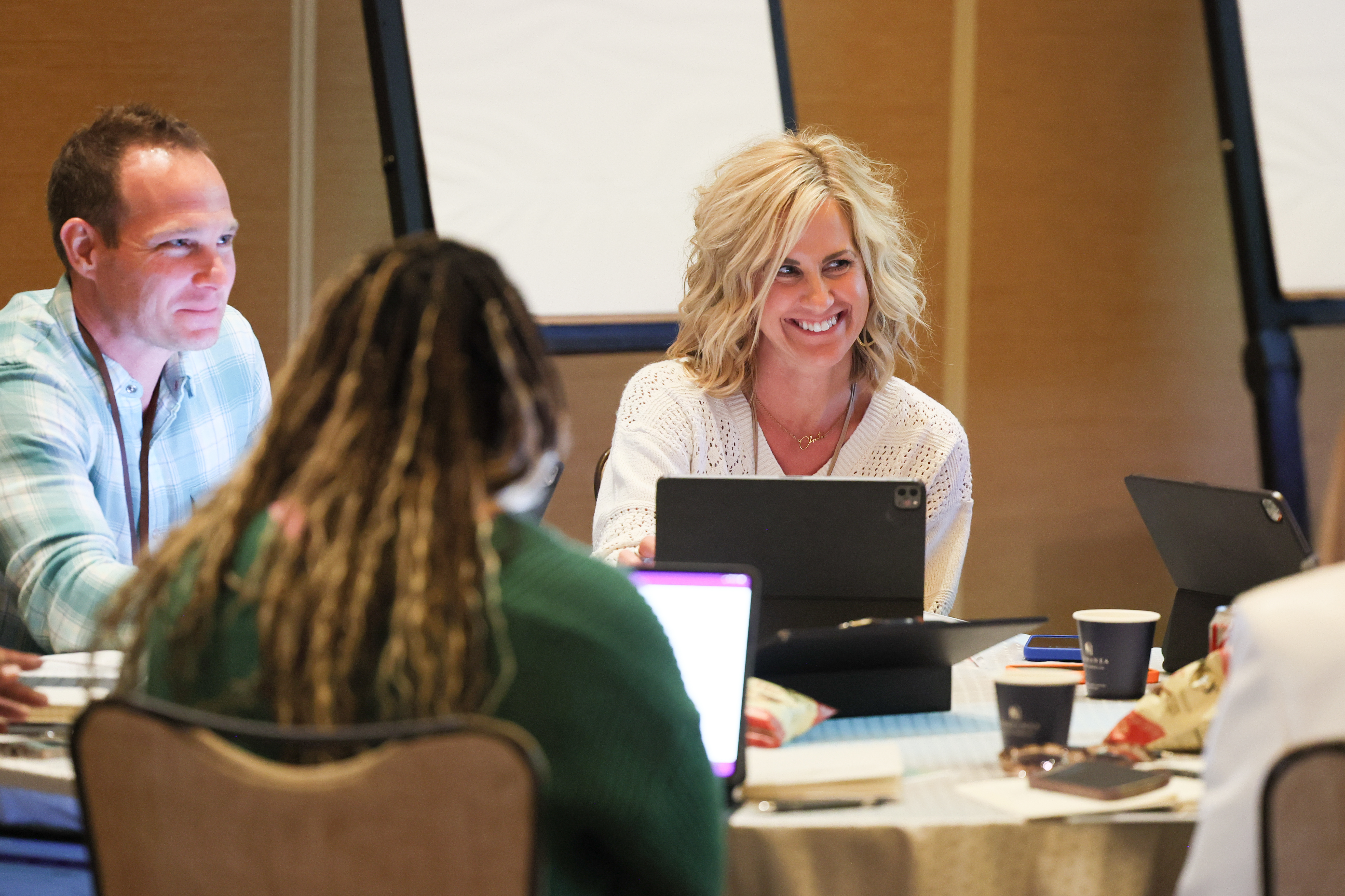 People sitting around a conference table smiling